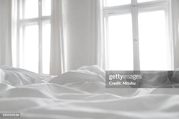 white bed linen - in bed stockfoto's en -beelden