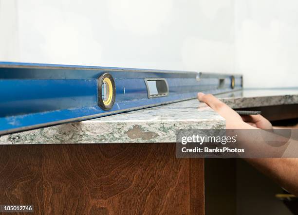 trabajador de instalar utilizando un nivel de superficie sólida encimera - kitchen counter fotografías e imágenes de stock