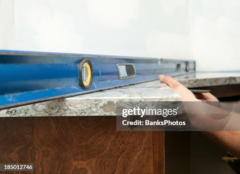 Worker Using a Level to Install Solid Surface Countertop Worker Using a Level to Install Solid Surface Countertop