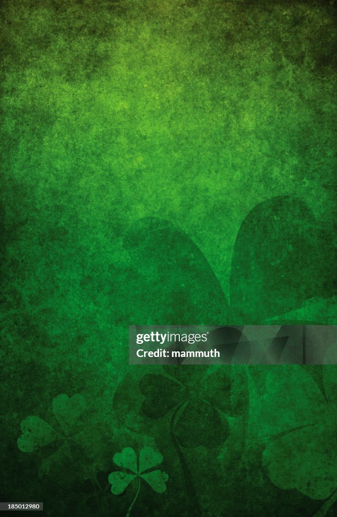 Grunge green background with four leaf clovers