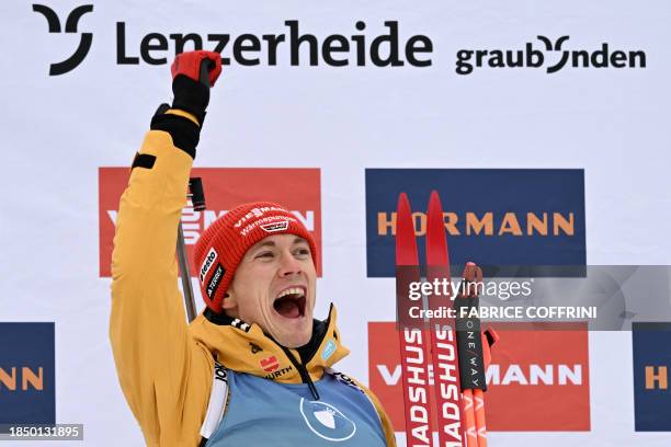 Germany's Benedikt Doll celebrates on the podium after winning the men 10km sprint event of the IBU Biathlon World Cup in Lenzerheide, eastern...