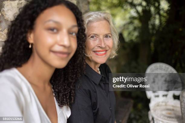 portrait of smiling granddaughter and grandmother outside house - granddaughter stock pictures, royalty-free photos & images