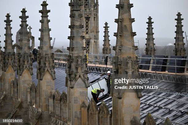 Solar panels are installed on the roof of King's College chapel in Cambridge, eastern England on December 13, 2023. High above the historic streets...