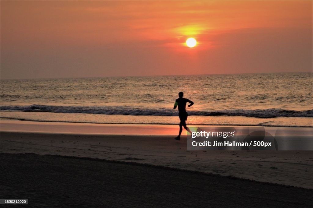 Silhouette of man walking at beach against sky during sunset,Sea Isle City,New Jersey,United States,USA
