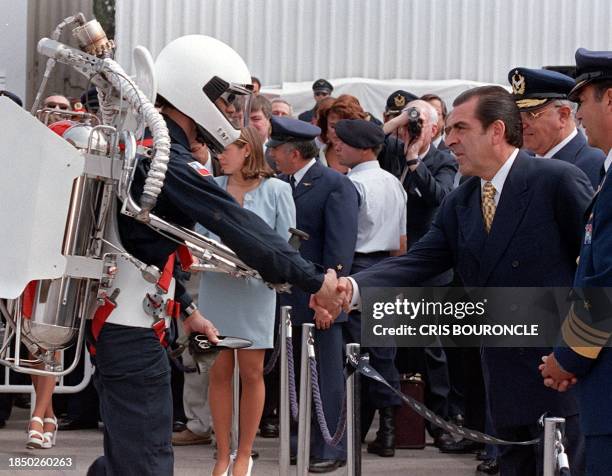 Chilean President Eduardo Frei shakes hands with a pilot who completed a demonstrating a rocket pack during the inauguration ceremony of the FIDAE...