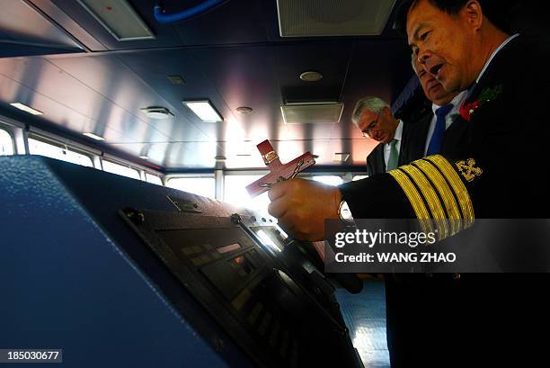 Captain holds a cross as he checks out a bulk carrier of Louis Dreyfus Armateurs Group during a naming ceremony for bulk carriers at a shipyard in...