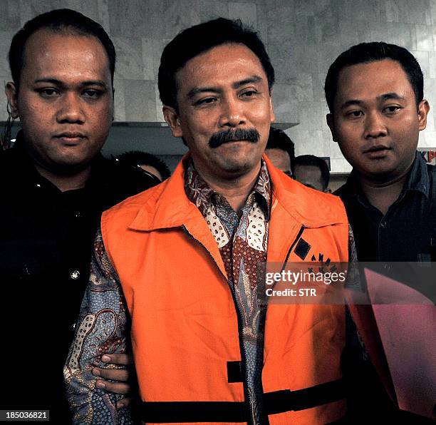 Indonesia's former sports and youth minister Andi Mallarangeng is escorted by guards at the Corruption Eradication Commission in Jakarta following...