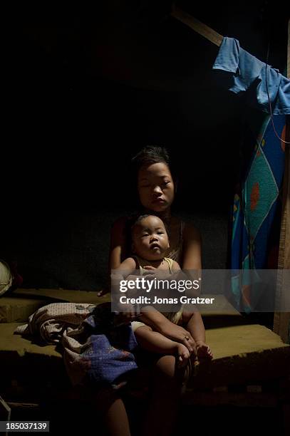 Month old baby sits in her 14 year old mother's lap; she is forced to make a living through prostitution to raise her daughter and pay for her room...