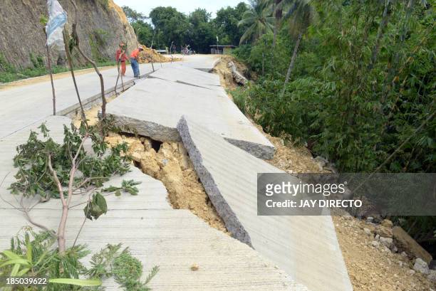 Workers from the Department of Public Work Highway inspect a road in the Village of Cantam-is, Bohol on October 17 that was damaged during a...