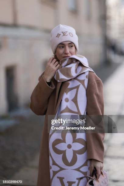 Sonia Lyson seen wearing Louis Vuitton light purple / rose / beige logo pattern oversized wool scarf and wool knit beanie, We are PNTS black loose...