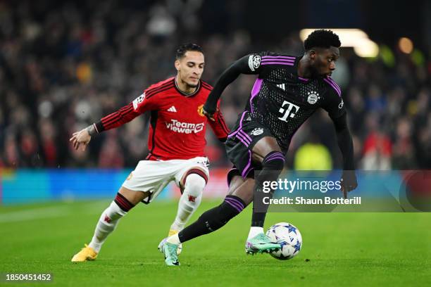 Alphonso Davies of Bayern Munich on the ball whilst under pressure from Antony of Manchester United during the UEFA Champions League match between...