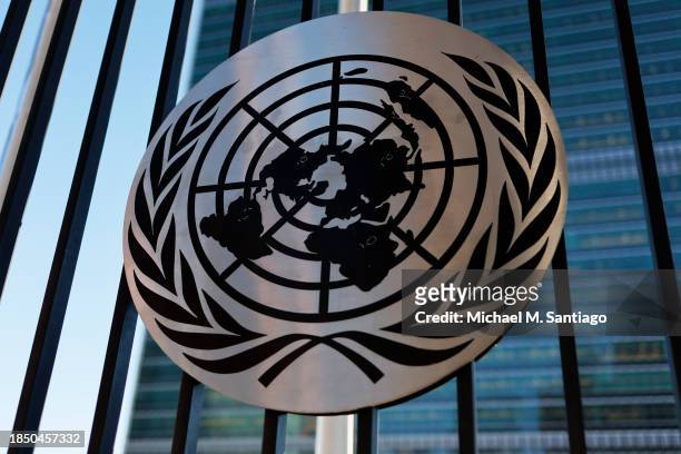 The United Nations logo is seen on a fence at the United Nations headquarters on December 12, 2023 in New York City. The General Assembly resumed its...