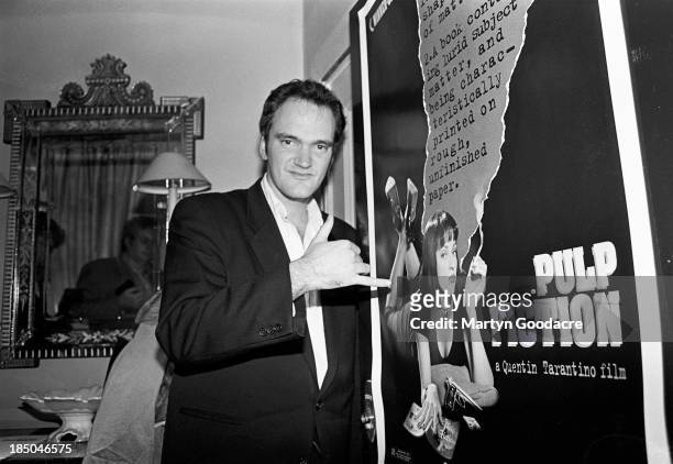 Director Quentin Tarantino standing by a poster for his film 'Pulp Fiction', London, United Kingdom, 1994.