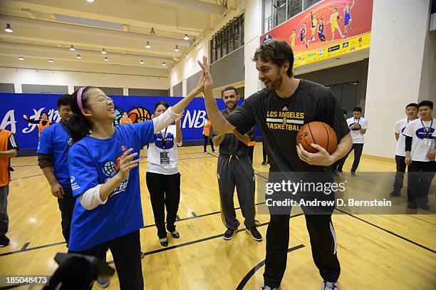 Pau Gasol of the Los Angeles Lakers high fives a participant during the NBA Cares Special Olympics Clinic as part of the 2013 Global Games on October...