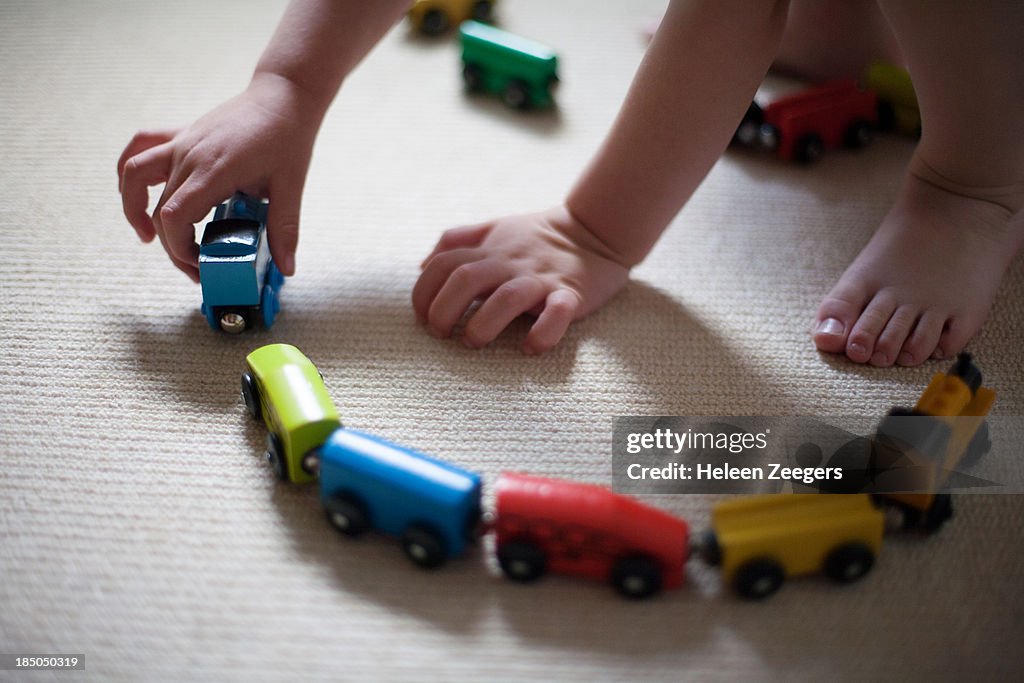 Hands playing with wooden train