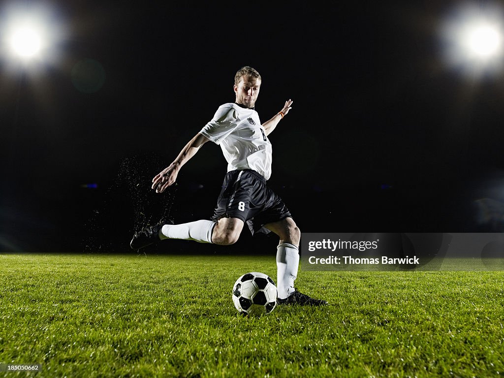 Soccer player about to kick ball on field
