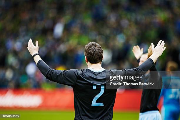 soccer players celebrating arms raised to crowd - professional sportsperson stock pictures, royalty-free photos & images