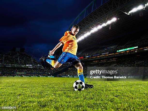 soccer player about to kick ball on field - floodlight stock pictures, royalty-free photos & images