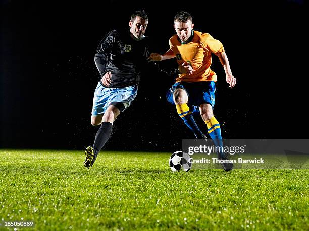 two soccer players challenging for ball - soccer player running stock pictures, royalty-free photos & images