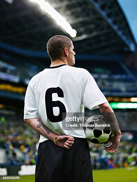 professional soccer player standing in stadium - fußballspieler stock-fotos und bilder