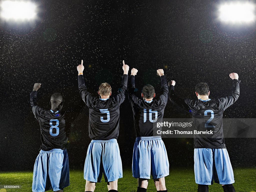 Professional soccer teammates celebrating on field