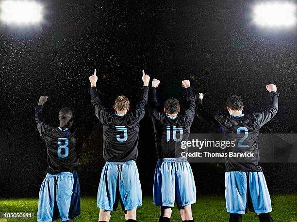 professional soccer teammates celebrating on field - campo da football americano - fotografias e filmes do acervo