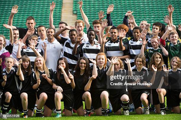 Prince Harry and former England International Jason Robinson pose with children taking part in the RFU All School Programme Coaching Event at...