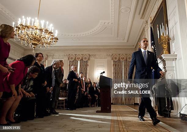 President Barack Obama leaves after speaking about the reopening of government following a shutdown in the State Dining Room of the White House in...