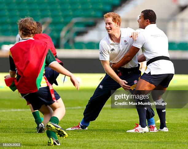 Prince Harry, in his role as Patron of the Rugby Football Union All Schools Programme and former England International Jason Robinson tussle as they...