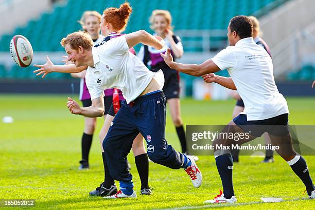 Prince Harry, in his role as Patron of the Rugby Football Union All Schools Programme and former England International Jason Robinson tussle as they...