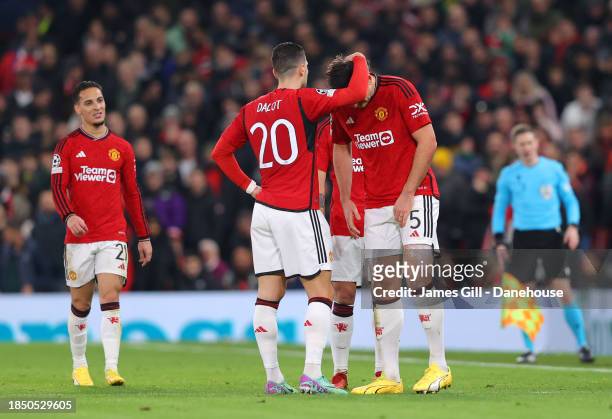 Harry Maguire of Manchester United is consoled by Diogo Dalot after getting injured and is substituted during the UEFA Champions League match between...