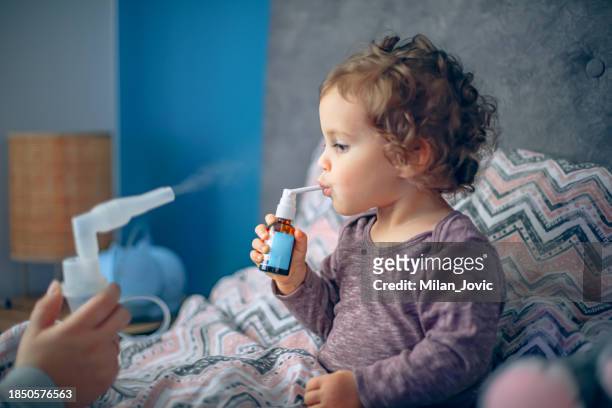 mother giving flu medicine to her sick child - serbia covid stock pictures, royalty-free photos & images