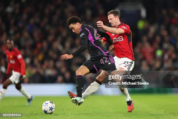 Jamal Musiala of Bayern Munich on the ball whilst under pressure from Jonny Evans of Manchester United during the UEFA Champions League match between...