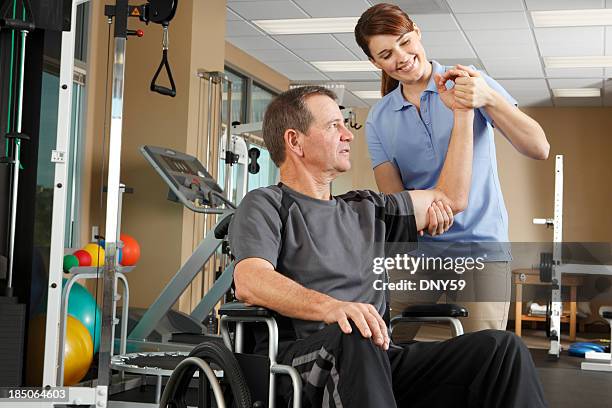 fisioterapeuta avaliar o intervalo de movimento de paciente em cadeira de rodas - paraplégico imagens e fotografias de stock