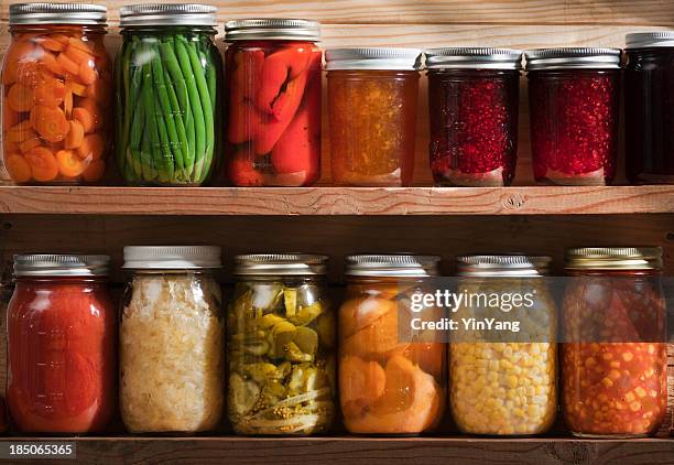 home canning, preserving, pickling food stored on wooden storage shelves - jar stockfoto's en -beelden