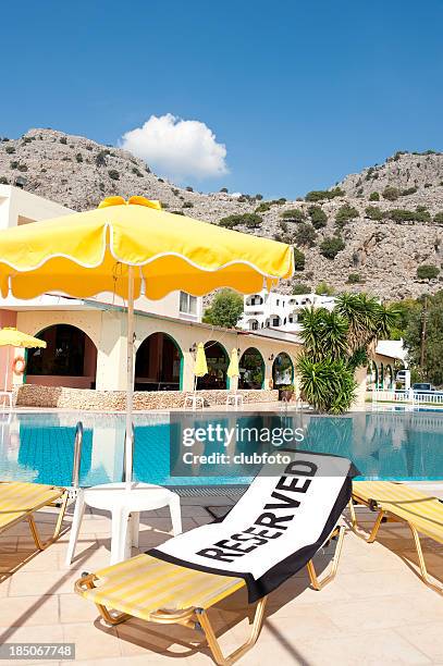 reserved'strandtuch mit einem leeren liegestuhl - sonnenliege stock-fotos und bilder