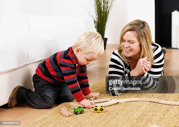 mother and toddler playing with train set in the lounge - miniature train stock pictures, royalty-free photos & images