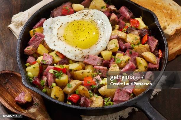 corned beef hash with a fried egg - corned beef breakfast stock pictures, royalty-free photos & images