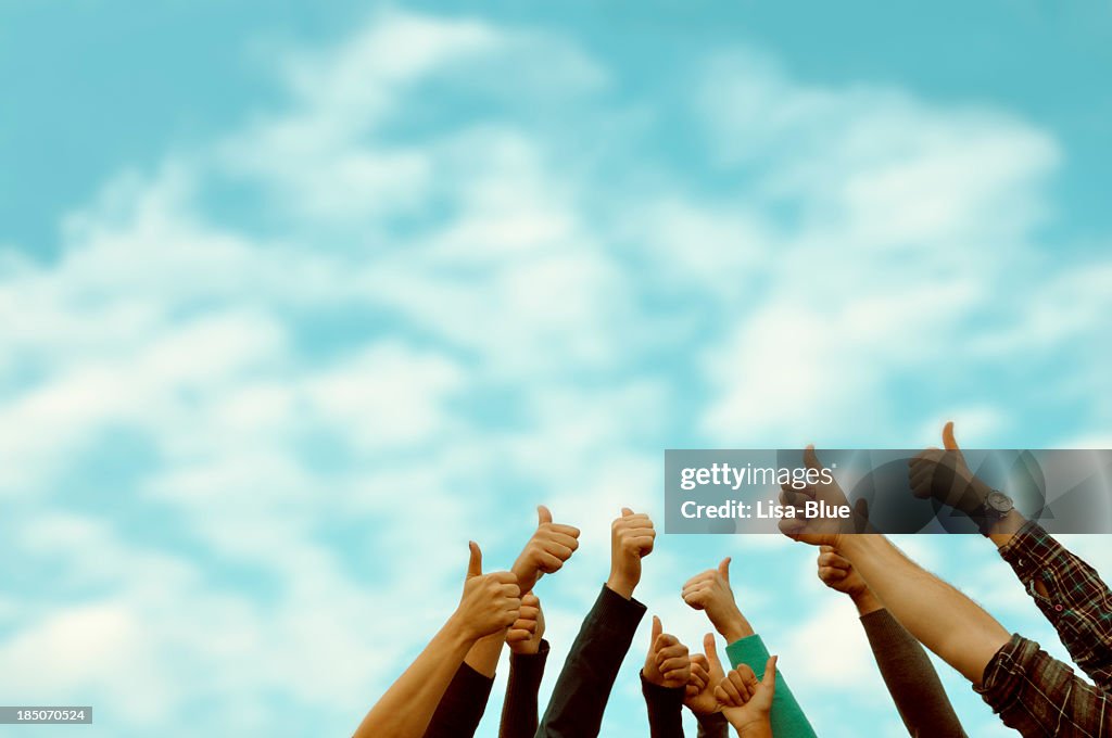 Group of people thumbs up blue sky