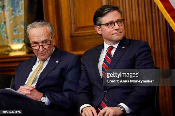 Senate Majority Leader Chuck Schumer and U.S. Speaker of the House Mike Johnson listen during remarks at a Capitol Menorah lighting ceremony at the...