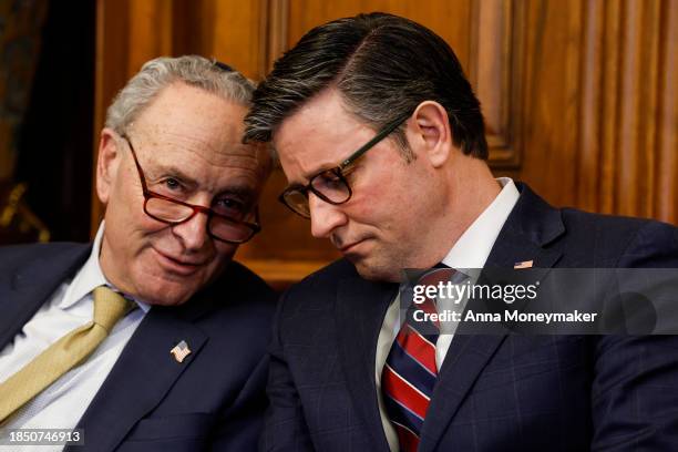 Senate Majority Leader Chuck Schumer and U.S. Speaker of the House Mike Johnson speak to one another during remarks at a Capitol Menorah lighting...