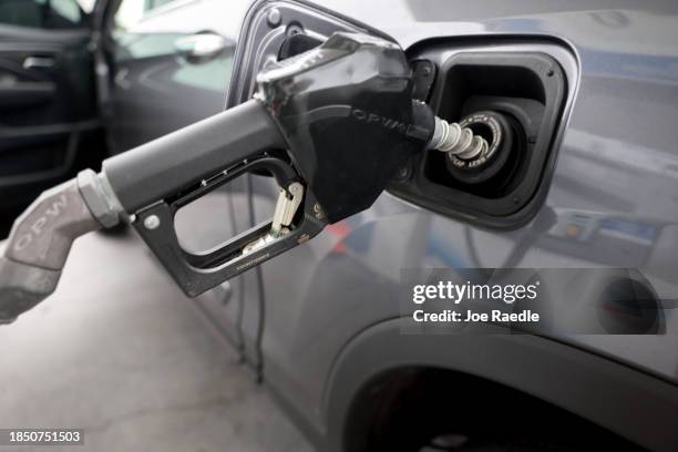 Customer pumps fuel into a vehicle at a gas station on December 12, 2023 in Miami, Florida. The national average for unleaded gas was $3.14 a gallon...