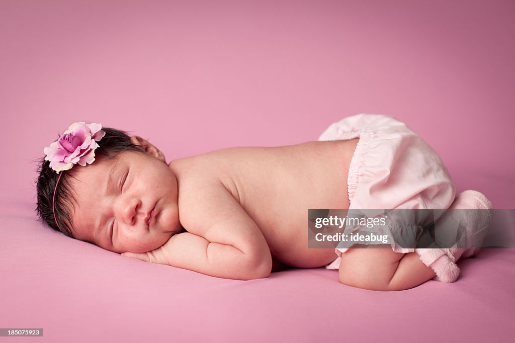 Image en couleur de précieux nouveau-né bébé fille, sur fond rose