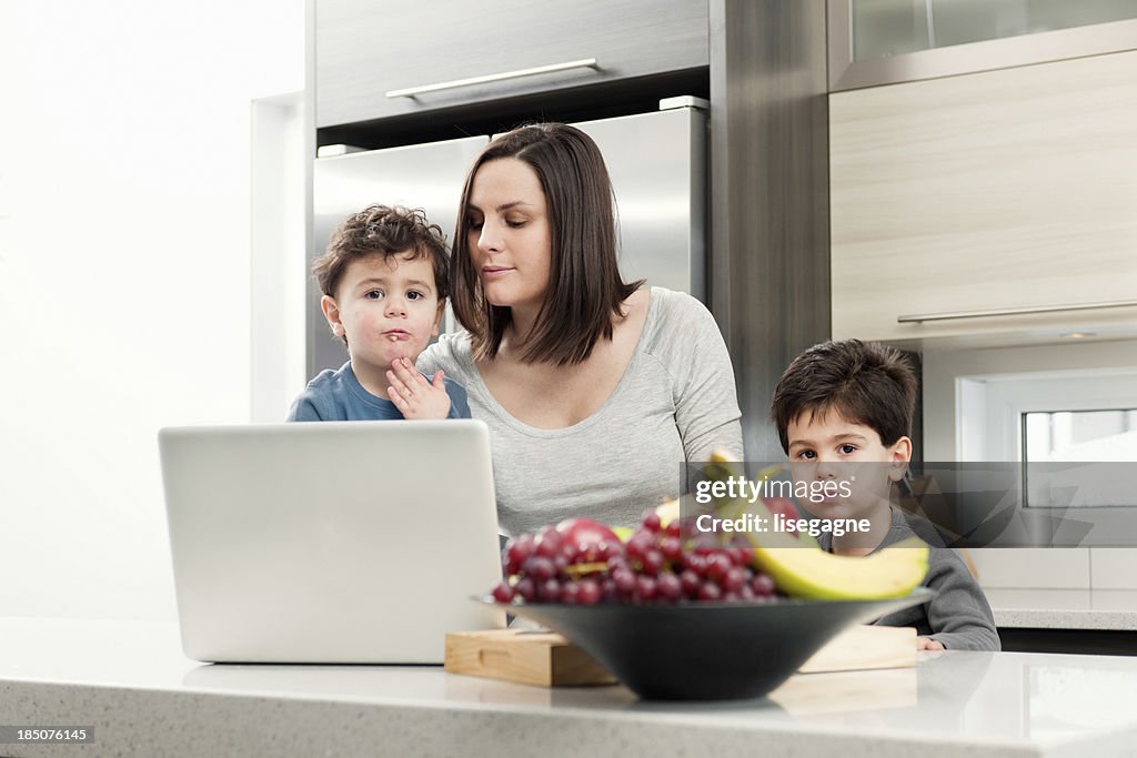 Pregnant woman with sons in kitchen