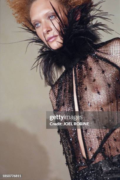 French model Christelle Saint-Louis Augustin presents a transparent shirt with a feather during the Jean-paul Gaultier 1998-99 Fall/winter high...