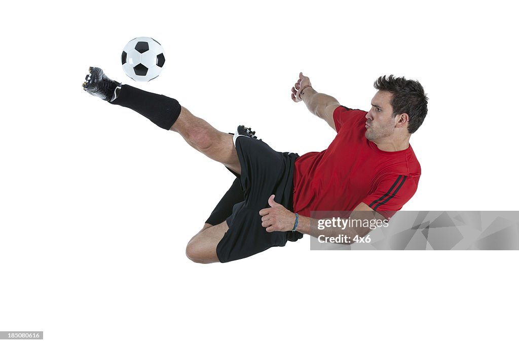 Homme shootant dans un ballon de football