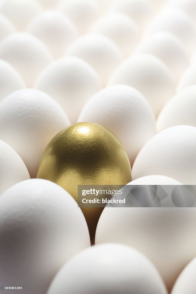 Goldene Ei in der Mitte von vielen regelmäßigen Eiern