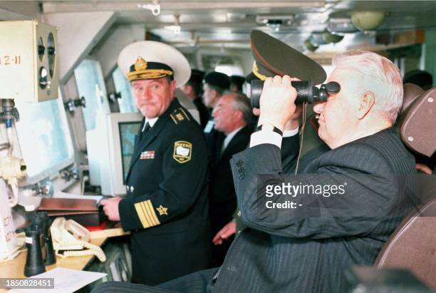 Russian President Boris Yeltsin uses binoculars to watch the combat trainings from missile cruiser "Pyotr Veliky" during his one-day visit to the far...