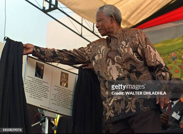South African President Nelson Mandela unveils a plaque bearing his portrait and Mozambican counterpart Joaquim Chissano, 6 June, at the launch of...