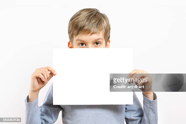giovane ragazzo che tiene vuoto foglio di carta - placard foto e immagini stock